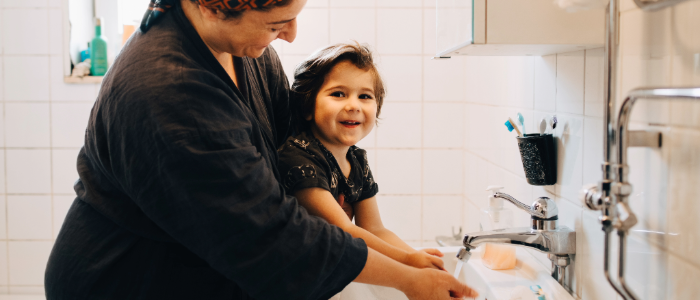Mom and son washing hands together to stay healthy during flu season.