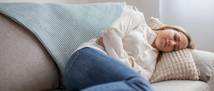 Woman experiencing cramping and pain, a common symptom of PCOS