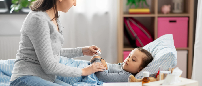 Parent helping child with norovirus symptoms at home