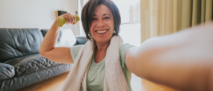 Middle-aged woman exercising with light dumbbells to strengthen bones and prevent osteoporosis