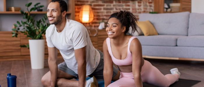Couple stretching on yoga mats to promote joint health and prevent arthritis.