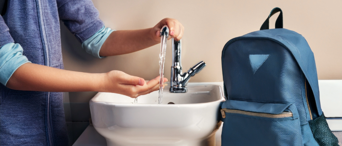 Student washing hands at school to prevent illness