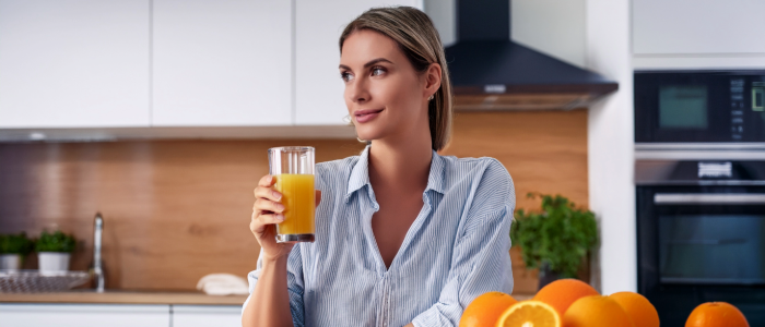 Person treating hypoglycemia by drinking orange juice.