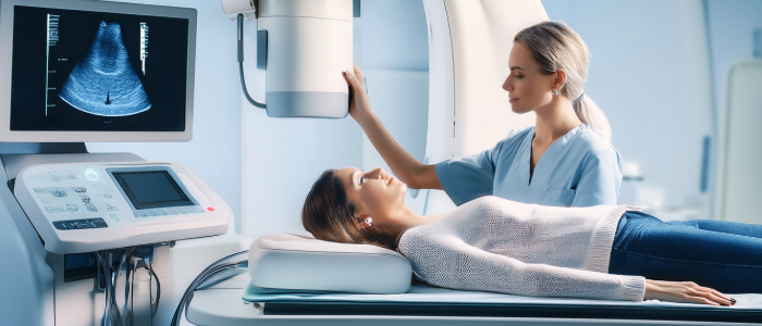 Technician performing a 透视 scan while patient lies on imaging table beneath x射线 equipment.