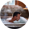 Person preparing for a cold plunge in an ice bath, with thermometer showing cold water temperature under 60°F, commonly used for muscle recovery.